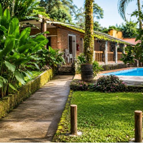 a pathway leading to a house with a swimming pool at Pousada Rancho Texas Ubatuba in Ubatuba