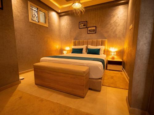 a bedroom with a large bed and a chair at Eco Farm Tayssir Marrakech in Marrakesh