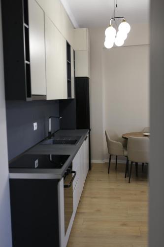 a kitchen with black and white cabinets and a table at Boulevard View in Tirana