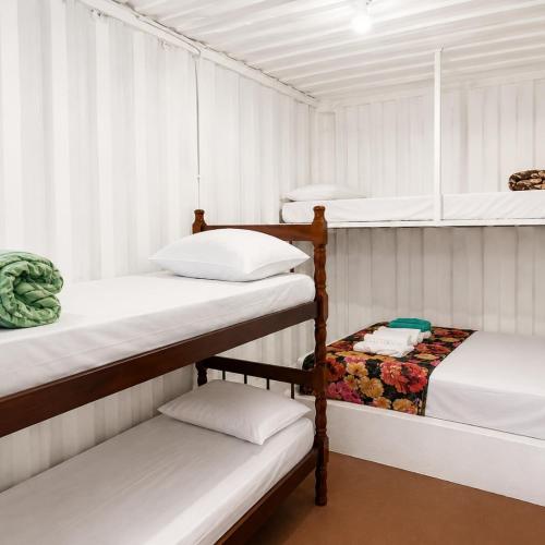 two bunk beds in a room with white walls at Pousada Rancho Texas Ubatuba in Ubatuba