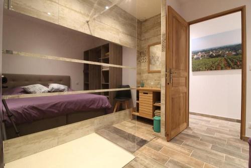 a bedroom with a bed and a large glass door at Mise au Verre in Prémeaux