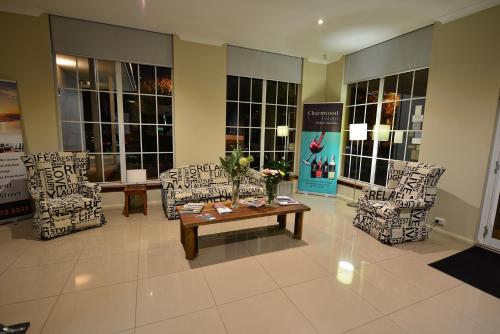a lobby with chairs and a table in a building at Winning Post Motor Inn in Mudgee