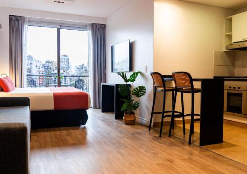 a hotel room with a bed and a kitchen at Reco by DOT Suites in Buenos Aires