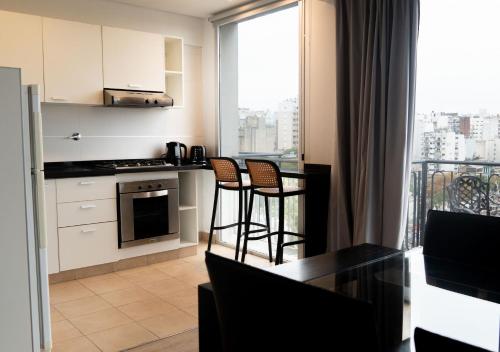 a kitchen with a table and chairs and a kitchen with a window at Reco by DOT Suites in Buenos Aires