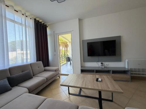 a living room with a couch and a table at Near movenpic apartament in Draç