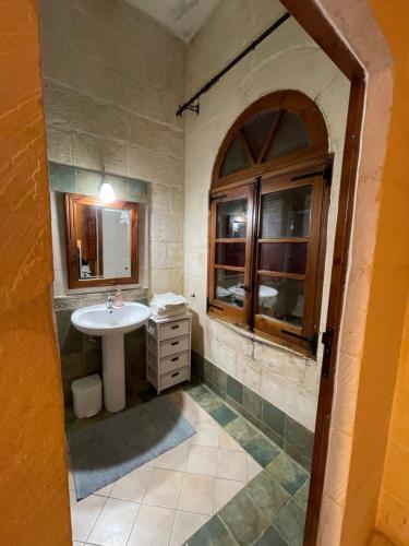 a bathroom with a sink and a mirror at Kercem Boutique Farmhouse in Kerċem
