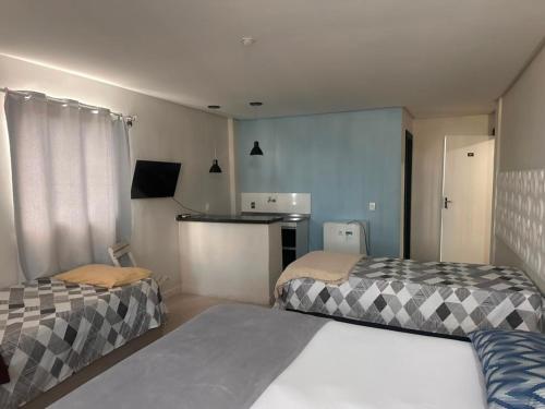 a small room with two beds and a kitchen at Vila Suites hotel in Vila Velha