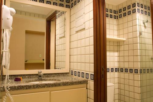 a bathroom with a sink and a mirror at Mercure Recife Navegantes in Recife