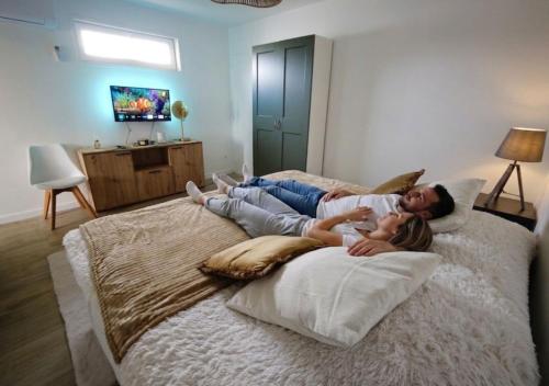 a woman and a girl laying on a bed at Bambou Zen Room in Rang-du-Fliers