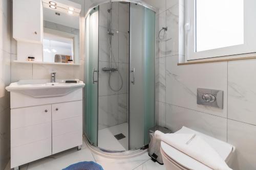 a bathroom with a glass shower and a sink at Haraki Bay Hotel and Luxury Apartments in Haraki