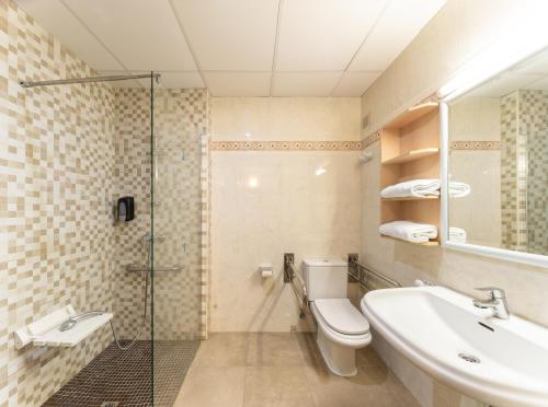 a bathroom with a toilet and a sink and a shower at Hotel Natura Park in Comarruga
