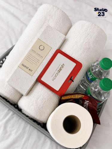 a tray with toilet paper towels and a bottle of water at Studio B23 Azure North in San Fernando