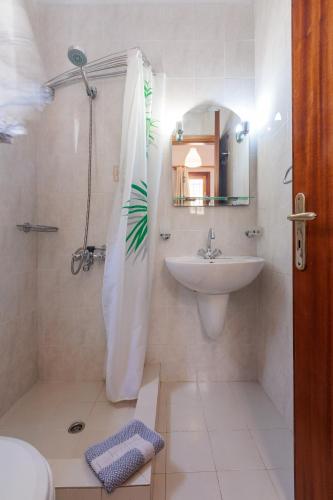 ein Badezimmer mit Dusche, Waschbecken und Spiegel in der Unterkunft Sunblaze Studios1 Spetses in Spetses