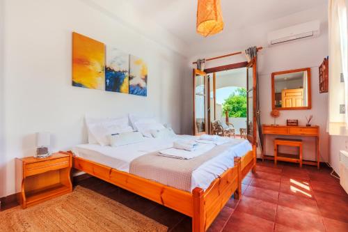ein Schlafzimmer mit einem großen Bett und einem Spiegel in der Unterkunft Sunblaze Studios1 Spetses in Spetses