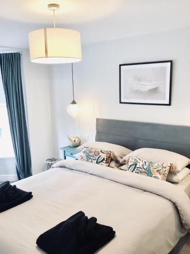 a bedroom with a large bed with two pillows at Derbyshire House Apartment 3 - Cavendish in Buxton