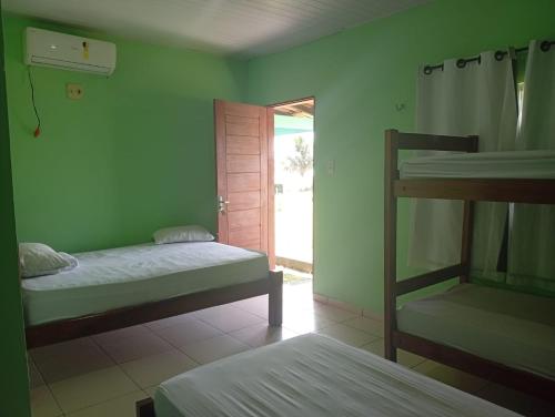 a room with two bunk beds and a door to a patio at Pousada Don Melo in Salvaterra