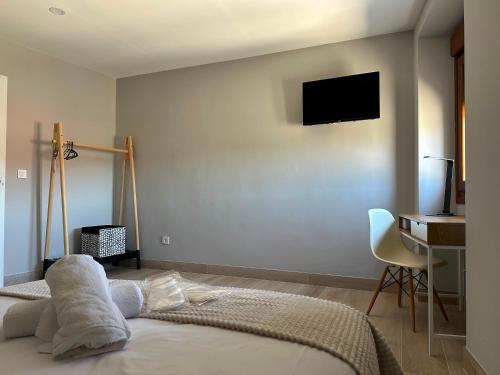 a bedroom with a bed with a television on the wall at Pensión Eirín VI in Caldas de Reis