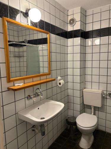 a bathroom with a sink and a toilet and a mirror at Family Hotel Verona in Sozopol