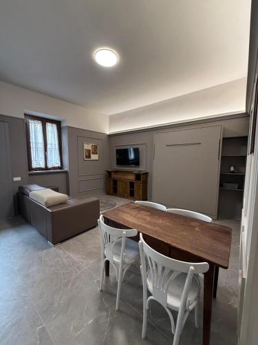 a living room with a table and chairs and a couch at Il campanile in Corbetta