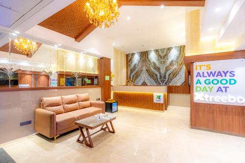 a waiting room with a couch and a sign at Treebo Premium Merrit in Katrab