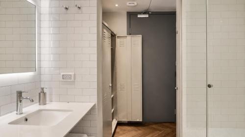 a bathroom with a sink and two stalls in it at Florentin House with MAMAK - By HOMY in Tel Aviv