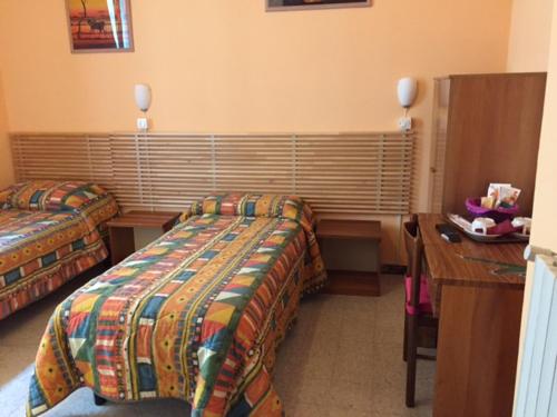 ein Hotelzimmer mit 2 Betten und einem Schreibtisch in der Unterkunft Affittacamere Euro in Ancona