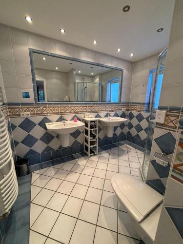 a bathroom with two sinks and a mirror at Haus Strandkind in Sylt