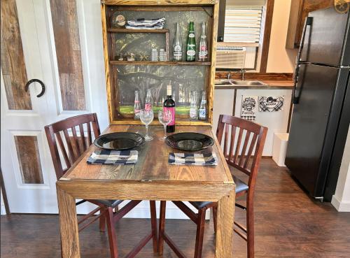 a wooden table with two wine glasses and a refrigerator at The bunkhouse in Sarasota