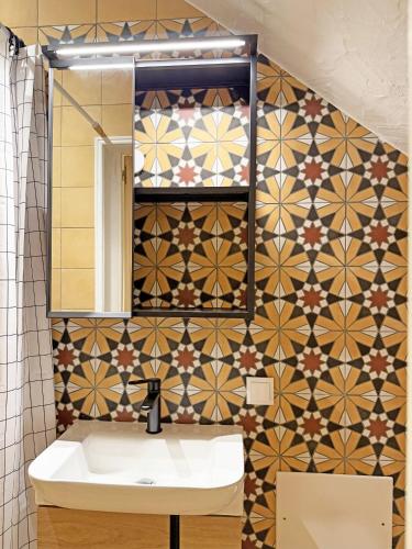 a bathroom with a sink and a tiled wall at Yellow Flamingo Studio Fuseta in Fuzeta