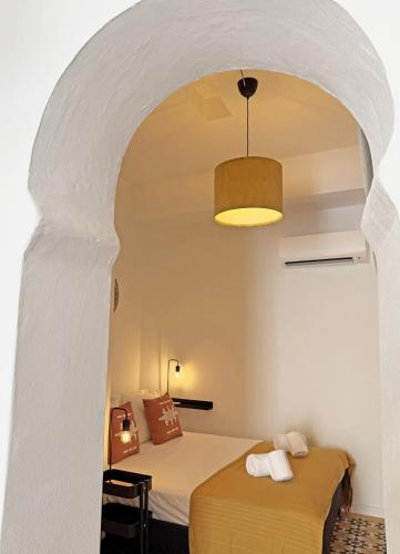 a bedroom with two beds in a room with an archway at Yellow Flamingo Studio Fuseta in Fuzeta