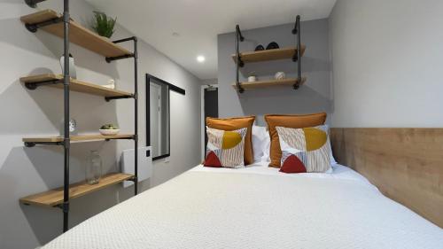 a bedroom with a bed with pillows and shelves at The Coal Yard in York