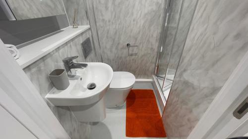 a white bathroom with a sink and a shower at The Coal Yard in York