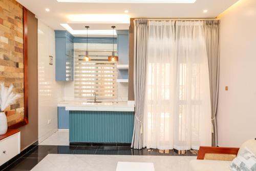 a kitchen with blue cabinets and a sink at Ruts Golden Homes in Kampala