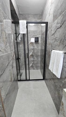 a shower with a glass door in a bathroom at Dereboyu Premium in Nicosia