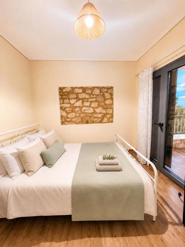 a bedroom with a large bed with a large window at Olive Coast House 3 100m from the sea in Kyparissia