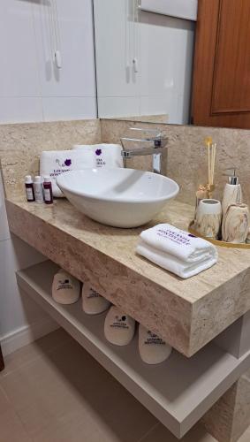 a bathroom counter with a bowl sink and towels at Locanda Montecielo Pousada Boutique - Vale dos Vinhedos in Bento Gonçalves