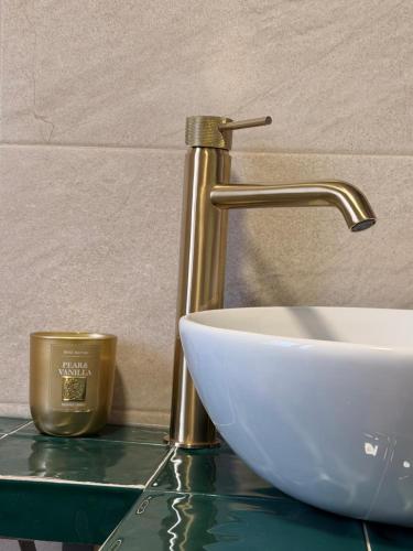 a bathroom sink with a gold faucet on a counter at Alcalá Zona Centro Duplex in Alcalá la Real