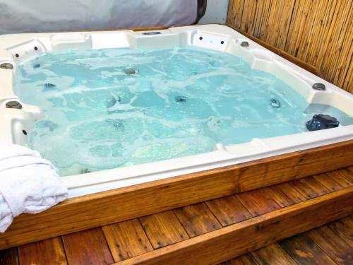 a jacuzzi tub with blue water in a wooden deck at אחוזת החושן - וילה מהממת עם בריכה פרטית in Tirosh