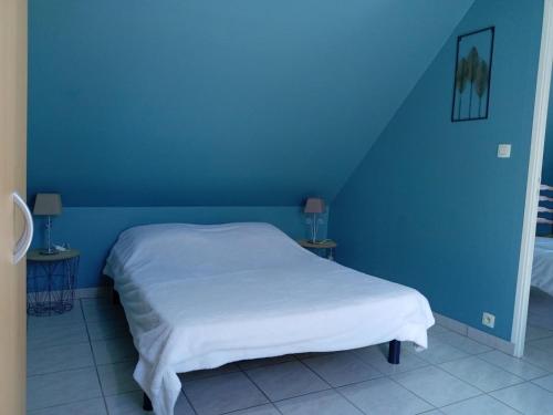 a blue bedroom with a white bed and blue walls at Gite du neufbourg in Courtils