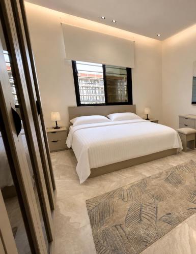 a bedroom with a large white bed and a window at Toot Suites in Abha