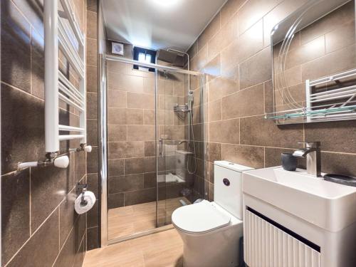 a bathroom with a toilet and a shower and a sink at David Palace Hotel Ureki in Ureki