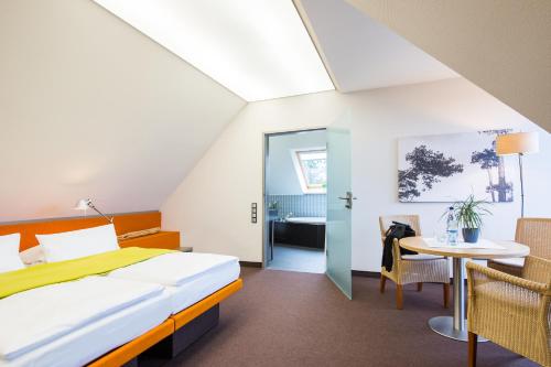 a hotel room with a bed and a table at Hotel Windschur in Sankt Peter-Ording
