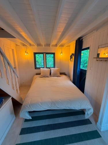 a bedroom with a large bed in a small room at La Cabane du Pti' Bonheur in Saint-Coulomb