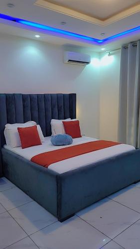 a large bed with red pillows on it in a room at Cité La Vie in Douala