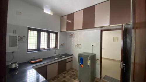 a kitchen with a sink and a refrigerator at Future homes in Kunnamkulam