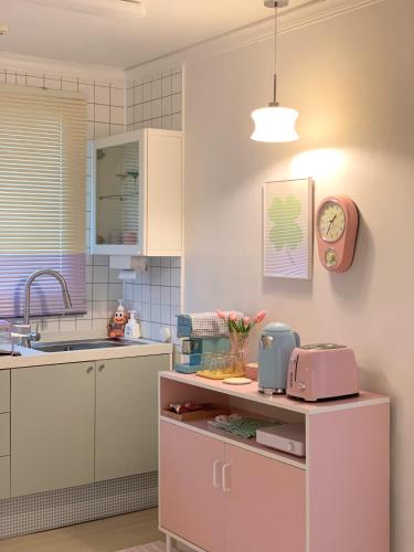 a kitchen with a sink and a clock on the wall at stay mongle in Suwon