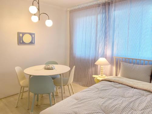 a bedroom with a bed and a table and chairs at stay mongle in Suwon
