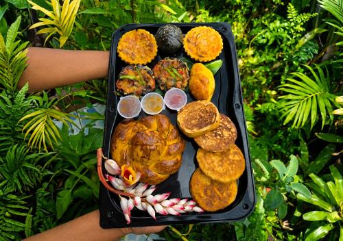 a person holding a tray filled with food at Lov'appart in Les Anses-dʼArlets