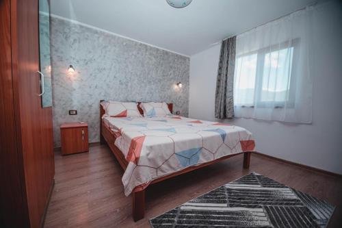 a bedroom with a bed and a window at Casa Andrei in Eşelniţa