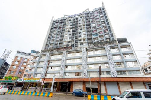 a tall building with cars parked in front of it at Treebo Premium Merrit in Katrab